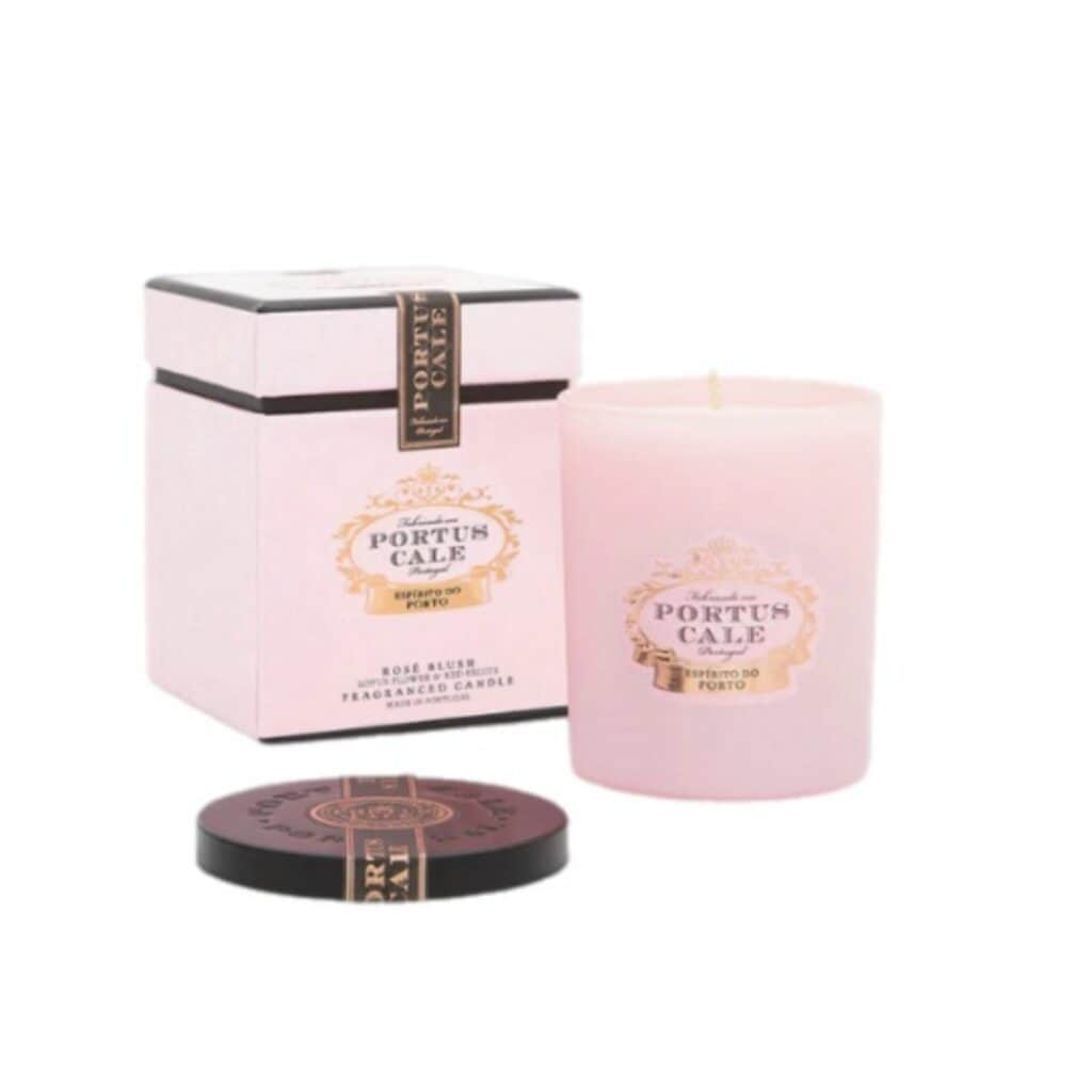 נר ורוד Portus Cale - Ruby Red מונח בתוך מיכל זכוכית עם קופסה ורודה ושחורה תואמת ומכסה שחור. על התווית כתוב "Portus Cale, Rose Blush, נר ריחני, פורטו". - vavaVoom.co.il