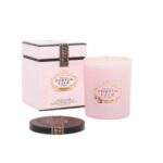 נר ורוד Portus Cale - Ruby Red מונח בתוך מיכל זכוכית עם קופסה ורודה ושחורה תואמת ומכסה שחור. על התווית כתוב "Portus Cale, Rose Blush, נר ריחני, פורטו". - vavaVoom.co.il