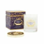 נר חגיגי בצבע כחול-לבן בניחוח נעים, בתוך מחזיק זכוכית עם תווית זהב ולבן, מוצג עם קופסתו הדקורטיבית בצבעי כחול וזהב, מכסה זהב, והכל על רקע לבן. - vavaVoom.co.il