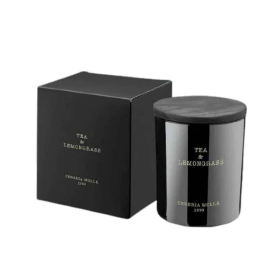 3e13e2f9-3206-4e80-9986-cb00545ec858 נר בצנצנת שחורה עם הכיתוב "TEA&LEMONGRASS - גר׳ 230" מונח לצד קופסה תואמת, שניהם עם הלוגו האלגנטי של CERERIA MOLLÁ 1899 בזהב. - vavaVoom.co.il