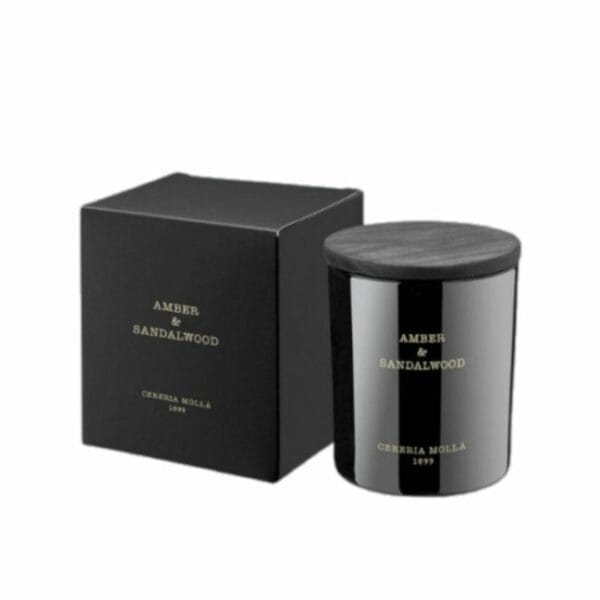 צנצנת נרות שחורה עם הכיתוב "נר קטן AMBER&SANDALWOOD - גר׳ 230" מונחת לצד הקופסה השחורה התואמת, ששתיהן מעוטרות בכיתוב זהוב פשוט על רקע לבן חלק. - vavaVoom.co.il